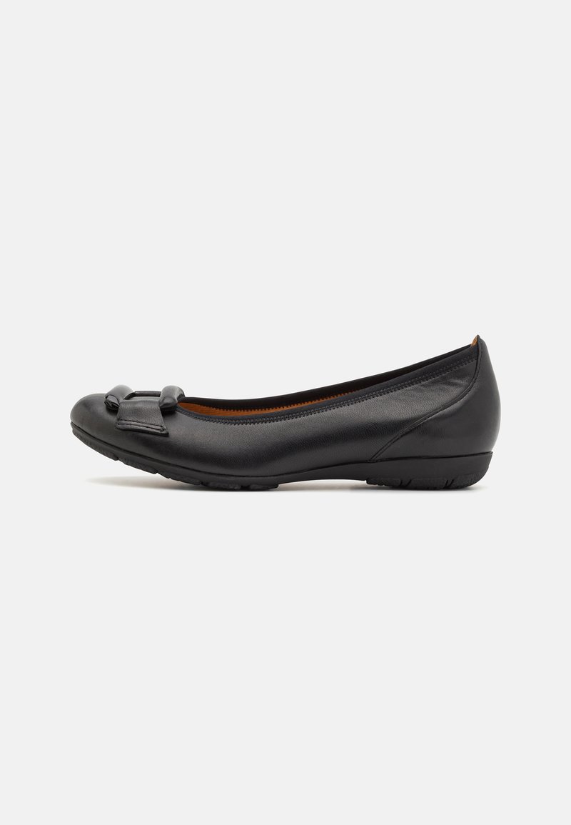 Bailarina de cuero negro con punta redondeada y pequeño lazo decorativo. Textura suave, suela flexible y diseño de tacón bajo.