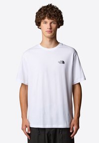 Camiseta de algodón blanca con un pequeño logo negro en el lado izquierdo del pecho, corte estándar, cuello redondo y mangas cortas.