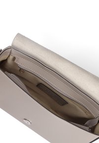 Borsa a mano in pelle beige con una texture liscia, apertura superiore e tasca interna con zip. Accentuata da una patta in suede e hardware in argento.