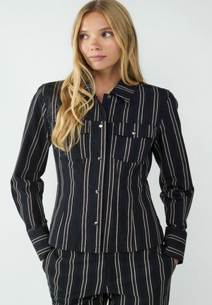 Zwart gestreepte shirt met twee borstzakken, knoopsluiting en lange mouwen, met een textuurstof met horizontale en verticale strepen.