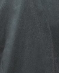 Tecido preto com uma textura suave e ligeiramente brilhante. A superfície apresenta variações subtis de cor e brilho, indicando reflexos de luz variados.