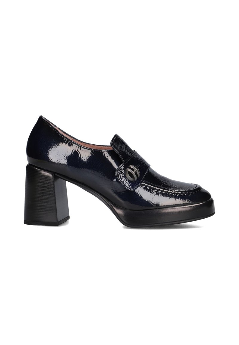 Navy patent leather block-heeled loafers with a rounded toe, decorative strap, and a circular metal accent on the strap.