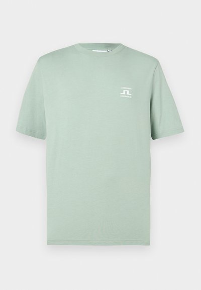 Απαλό πράσινο κοντομάνικο T-shirt με μικρό λευκό λογότυπο "J.LINDEBERG STOCKHOLM" στο αριστερό στήθος, στρογγυλή λαιμόκοψη, απλό σχέδιο.
