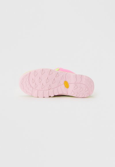 Sola em borracha rosa de ténis com padrões em forma de diamante e logótipo da Vibram, ténis deitados numa superfície branca.