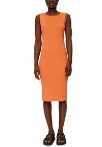 Ripponkleid in leuchtendem Orange, knielang mit quadratischem Ausschnitt und ärmellosem Design. Getragen mit schwarzen Riemchensandalen.