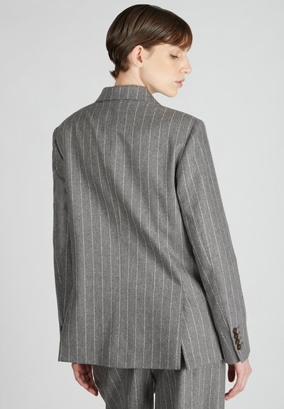 Blazer grigio a righe sottili realizzato in tessuto testurizzato, caratterizzato da uno spacco singolo e polsini abbottonati, con una silhouette su misura e rever affilati.