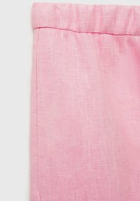 Pink linen fabric with a textured finish, showcasing a folded waistband and seam detail. Smooth appearance and lightweight feel.
