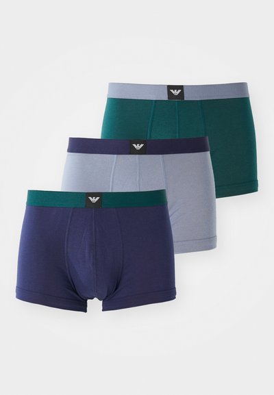 Tre par herreboxershorts i marineblå, teal og lysegrå. Laget av myk stoff med elastiske midjebånd som har et logomerke.