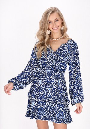 Blau-weiß gemustertes Kleid mit langen Ärmeln, rüschigem Saum und Kordelzug in der Taille. Leichter Stoff mit floralem Design.