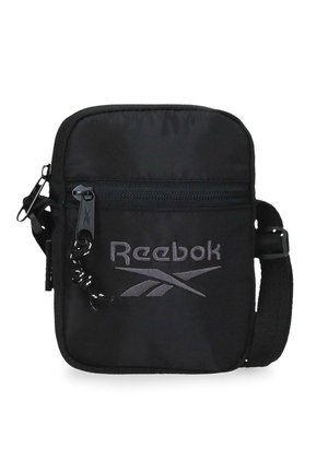 Bolso bandolera compacto negro con bolsillo frontal con cremallera, correa ajustable y logo gris de Reebok en el panel frontal.