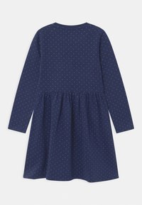 Langärmliges Kleid aus navyblauem Baumwollstoff mit weißen Punkten. Es zeichnet sich durch eine geraffte Taille, einen runden Ausschnitt und eine weiche Textur aus.