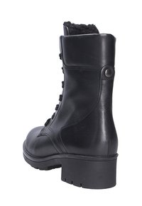 Zwarte leren enkelboot met een gestructureerde afwerking, vetersluiting en een stevige rubberen zool. Heeft een zachte voering aan de bovenkant.