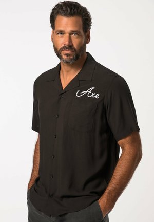 Camisa negra de manga corta en una tela suave, con botones en la parte delantera y un bolsillo con el texto bordado en blanco "Axe" en el lado izquierdo.