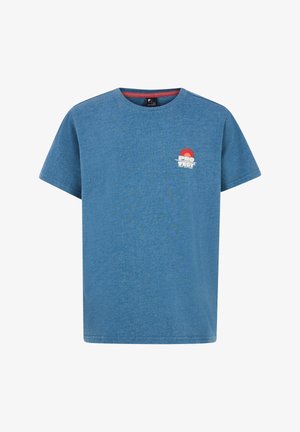 Personne portant un t-shirt bleu avec "PRO TEST SUN SEA SURF" et un graphisme de soleil rouge-orange, associé à un short rouge à motifs.