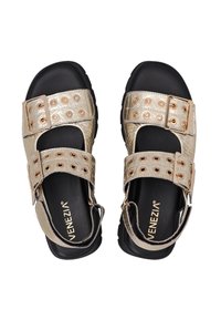Gouden sandalen met twee brede banden met ronde uitsparingen, verstelbare gespen en een gestructureerd oppervlak. Zwarte rubberen zolen. Merkennaam zichtbaar.