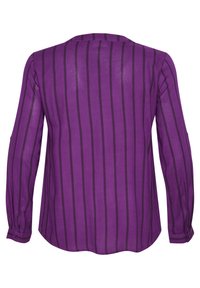 Blusa a maniche lunghe viola con strisce verticali nere, tessuto morbido, orlo arrotondato e polsini con bottoni. Nessun elemento grafico o motivo.