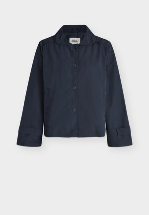 Μπλε ναυτικό μακρυμάνικο σακάκι με κουμπιά, γιακά και λουράκια στις μανσέτες, εμφανίζεται σε απλό ανοιχτό φόντο.