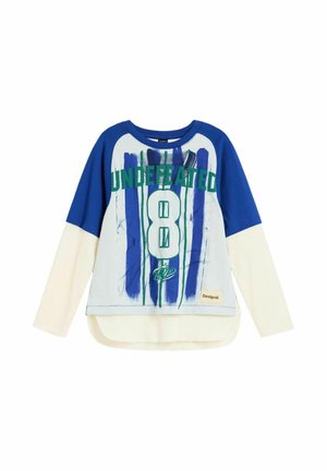 Langärmliges, geschichtetes Hemd mit blauen oberen Ärmeln, cremefarbenen unteren Ärmeln und grünem Schriftzug "Undefeated 8" auf blauen Streifen vorne.