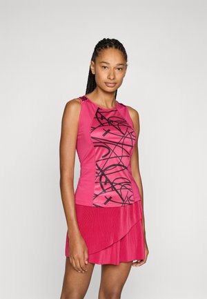 Rosa trenings tank top med et svart abstrakt design, som har teksturert stoff og skulderdetaljer. Kombinert med et plisserende rosa skjørt.