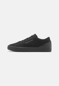 Czarne zamszowe sneakersy o niskim profilu, okrągłym nosku i czarnej gumowej podeszwie. Posiadają metalowe oczka i logo po boku. Teksturowany akcent na pięcie.
