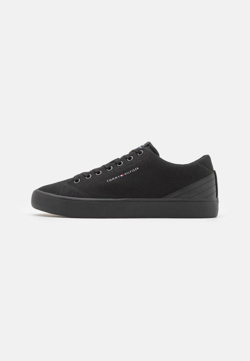 Czarne zamszowe sneakersy o niskim profilu, okrągłym nosku i czarnej gumowej podeszwie. Posiadają metalowe oczka i logo po boku. Teksturowany akcent na pięcie.