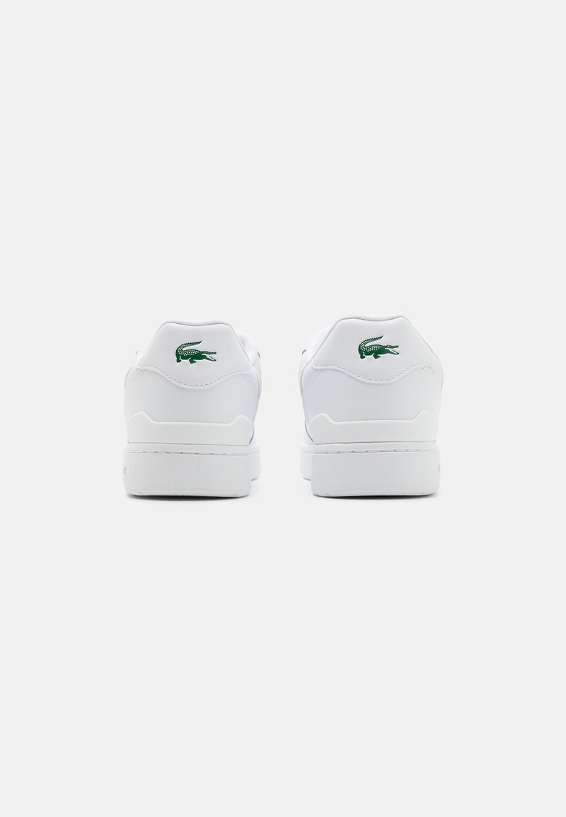 White leather sneakers with a smooth texture, featuring a green embroidered crocodile logo on the heel and a simple, low-profile design.
