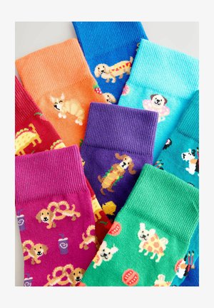 Barvni nogavice v različnih odtenkih z vzorci hišnih ljubljenčkov in hrane, vključno s psi v oblikah hrenovk, takosov in precveta. Ríbana struktura.