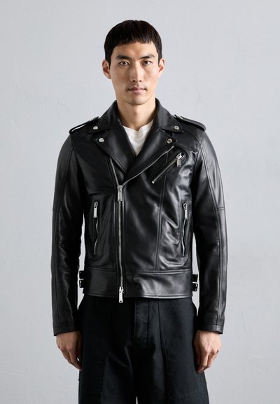 Black leather biker jacket with silver zippers and hardware, featuring an angled front zipper, side pockets, and a fitted design.