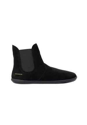 Stivaletto alla caviglia in suede nero con pannelli laterali elastici, suola piatta in gomma e logo "Groundies" nell'area del tallone.
