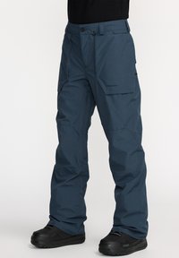 Blue waterproof snow pants with a straight-leg design, multiple pockets, and a logo accent. Made from durable material, ideal for cold weather.