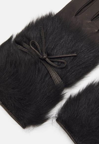 Guantes negros con una textura suave y parecida al pelo en el puño, palma de cuero y un detalle de lazo hecho de material negro texturizado.