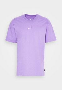 Paarse korte mouw t-shirt van katoen, met een klein wit Nike-logo op de borst. Eenvoudige ronde halslijn en een onopgemaakte uitstraling.