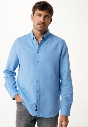 Light blue button-up shirt with a collared neckline, long sleeves, and a pocketless design. Made of a textured fabric. Pair of gray pants.