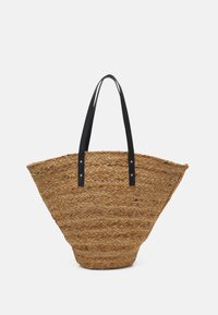 Woven straw tote bag with a wide, open shape. Black leather handles with visible stitching and rivets. Natural texture with a neutral color.
