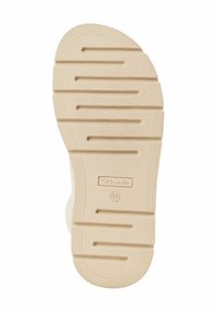 Light beige rubber shoe sole with horizontal and vertical grooves, marked with "Tamaris" branding and size "37" embossed.