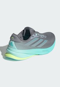 Scarpa da corsa leggera in mesh grigio con accenti in turchese. Dotata di una suola ammortizzata con un design a gradiente verde menta e giallo.