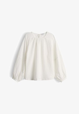 Blusa bianca a maniche lunghe con scollo rotondo, tessuto arricciato sul petto e maniche leggermente gonfie con polsini elastici.