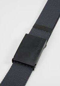 Textured gray fabric belt with a matte black metal buckle, featuring engraved brand name, and a secure fastening mechanism.