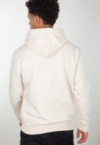 Felpa leggera beige vista da dietro. Presenta un cappuccio con cordoncino, tessuto texturizzato, polsini e orlo a costine, e una vestibilità comoda.
