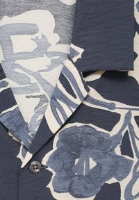 Camisetta a maniche corte di colore blu navy con grandi motivi floreali chiari. Presenta un colletto a rotondo, chiusura con bottoni e tessuto testurizzato.