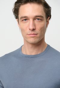 Enganliegende, kurzärmelige, blaue Rundhals-T-Shirt mit gerippter Textur. Schlichtes Design, ohne sichtbare Muster oder Akzente.