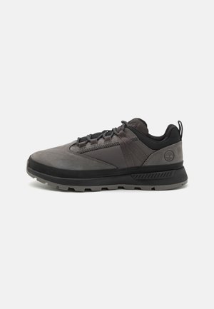 Chaussures d'extérieur noires et grises en cuir et mesh, dotées d'un col rembourré, d'une semelle texturée et d'un bout renforcé pour plus de durabilité.