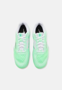 Hellgrüne Sportschuhe mit einem Mesh-Obermaterial, weißen Schnürsenkeln und einem schwarzen Innenfutter. Logo in Blau auf der Zunge und der Seite sichtbar.