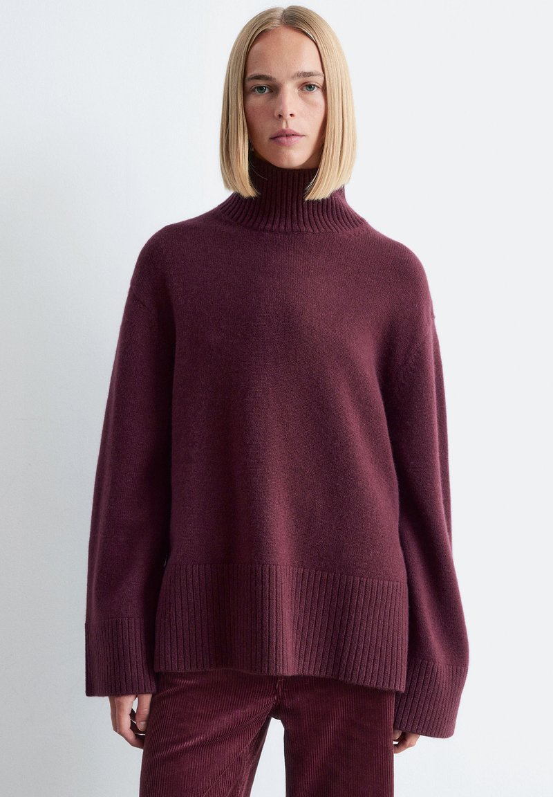 Burgunderfarbener Strickpullover mit hohem geripptem Kragen, weiten Ärmeln und geripptem Saum. Weiche Textur mit einer lässigen Passform.