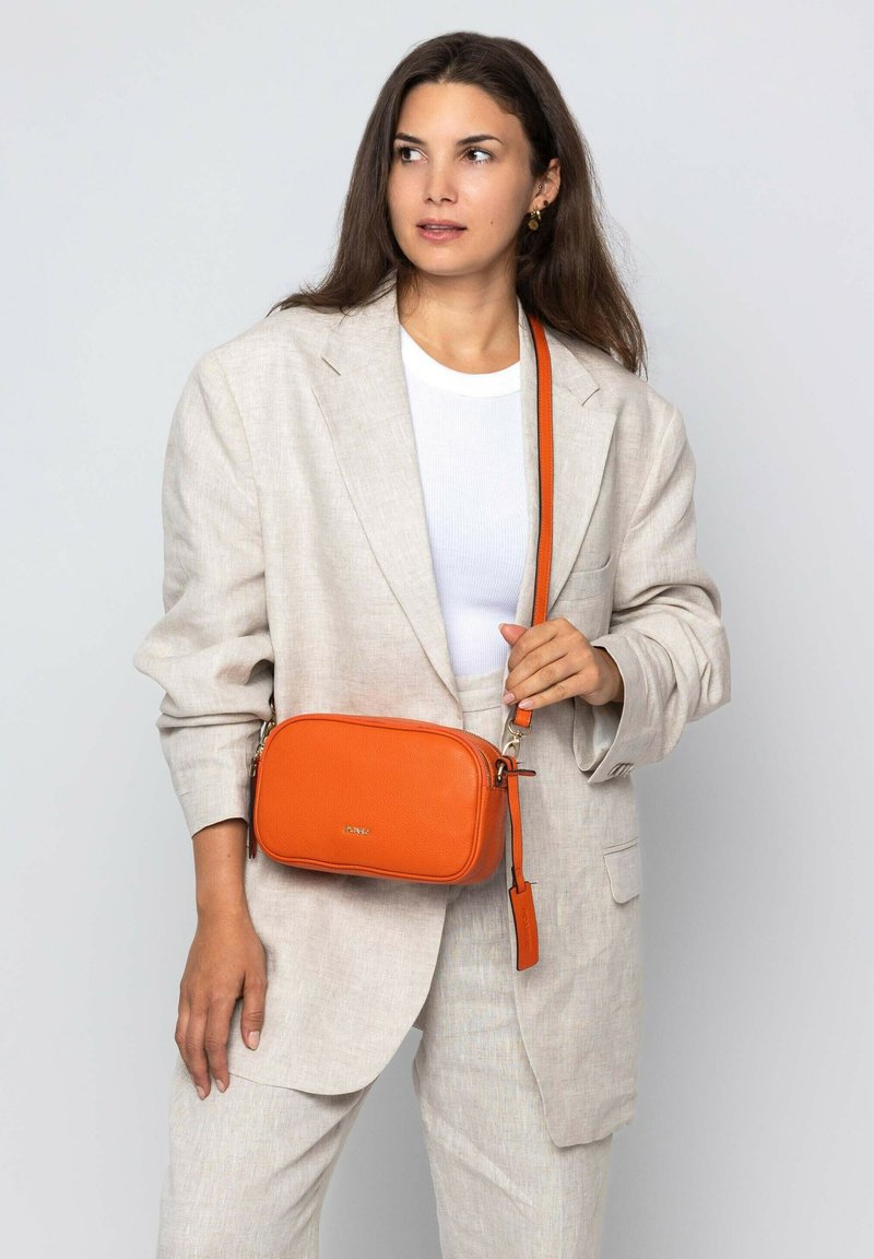 Orangefarbene Leder-Crossbody-Tasche mit rechteckiger Form, kontrastierendem Träger, silbernen Beschlägen und glatter Textur.