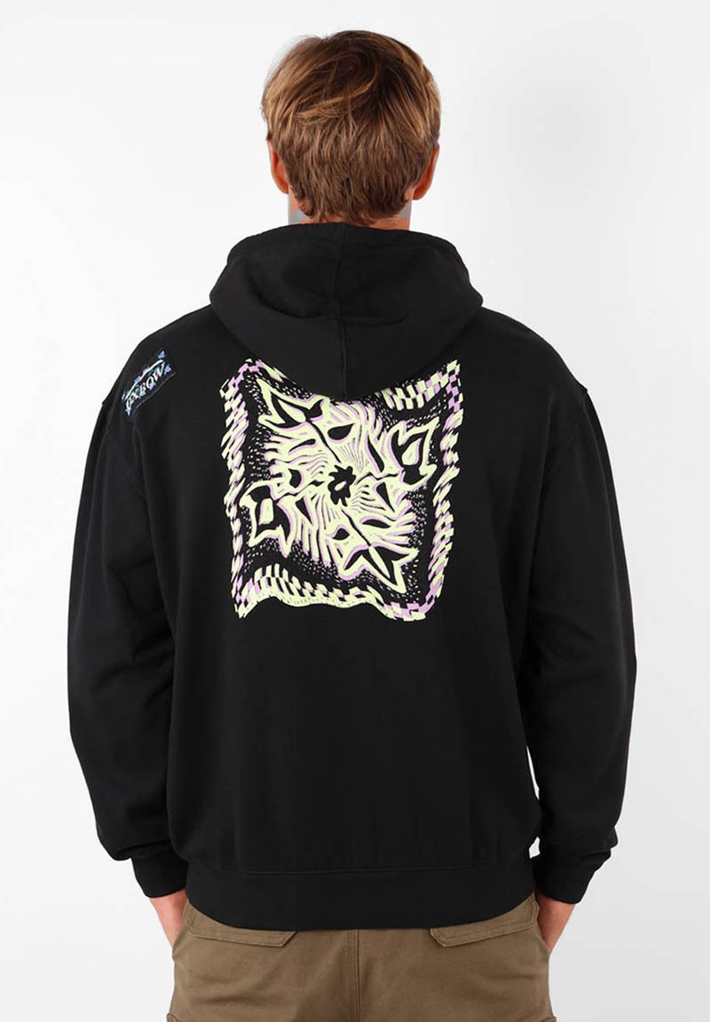 Haut à capuche noir avec un grand motif géométrique pastel au dos. Il dispose d'une poche kangourou et de poignets côtelés. Tissu texturé et lourd.