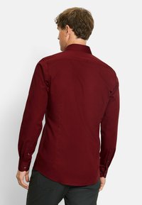 Bordeaux langemouwen shirt met knoopmanchetten en een standaard kraag; gladde textuur; aansluitende pasvorm met een gebogen zoom.
