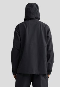 Czarna wodoodporna kurtka z kapturem, o gładkiej fakturze, luźnym kroju i regulowanymi mankietami. Widok od tyłu prezentuje minimalistyczny design.