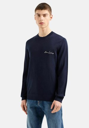Felpa lavorata a maglia blu navy con maniche lunghe, collo a giro e logo ricamato bianco sul lato sinistro del petto. Tessuto morbido e vestibilità regolare.