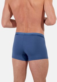 Niebieskie bokserki wykonane z miękkiej bawełnianej mieszanki, z kontrastującym elastycznym pasem w talii, na którym widocznie umieszczono logo. Krótkie nogawki.